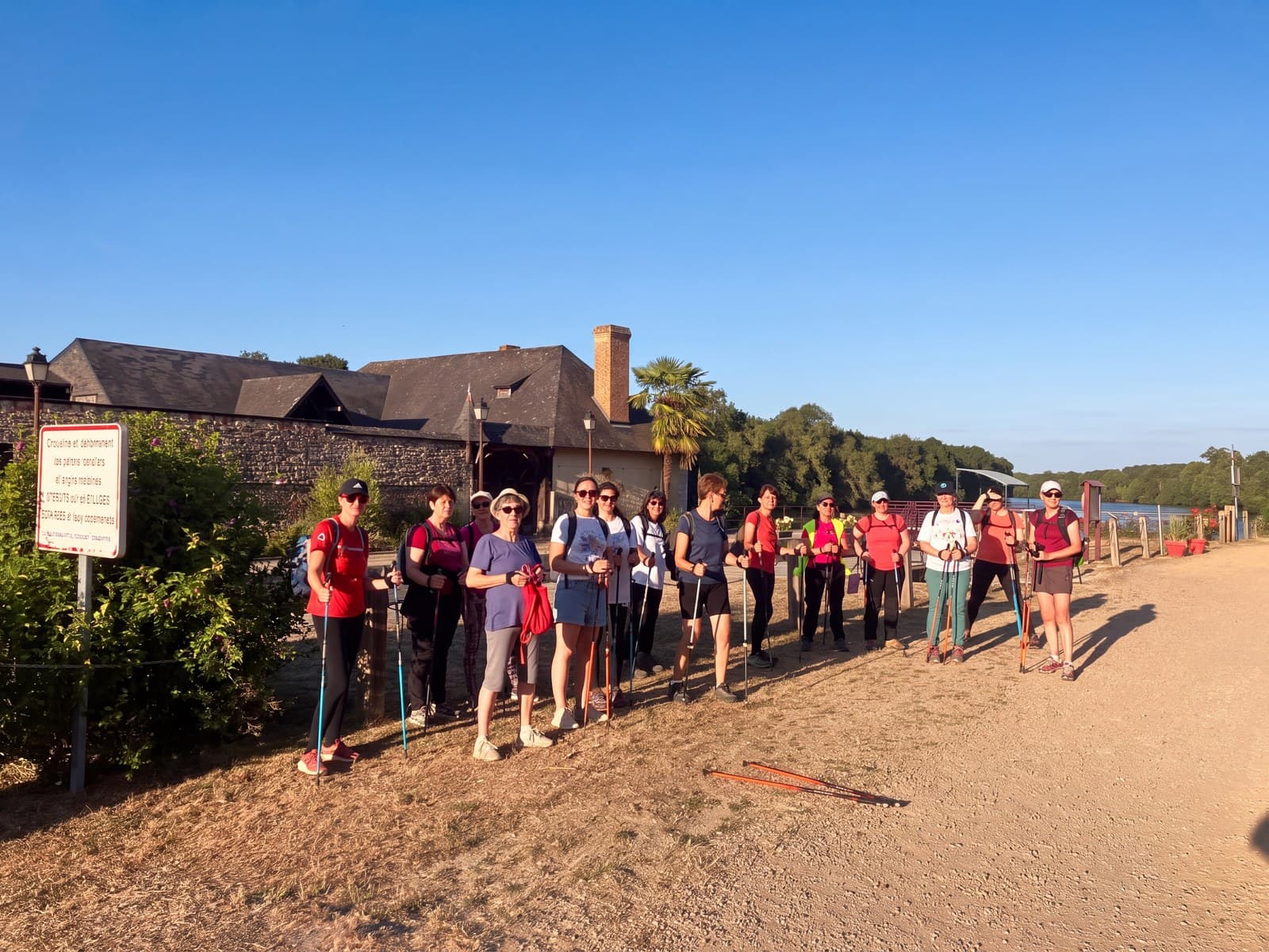Groupe de marche nordique du club, bâtons en main, devant une écluse.
